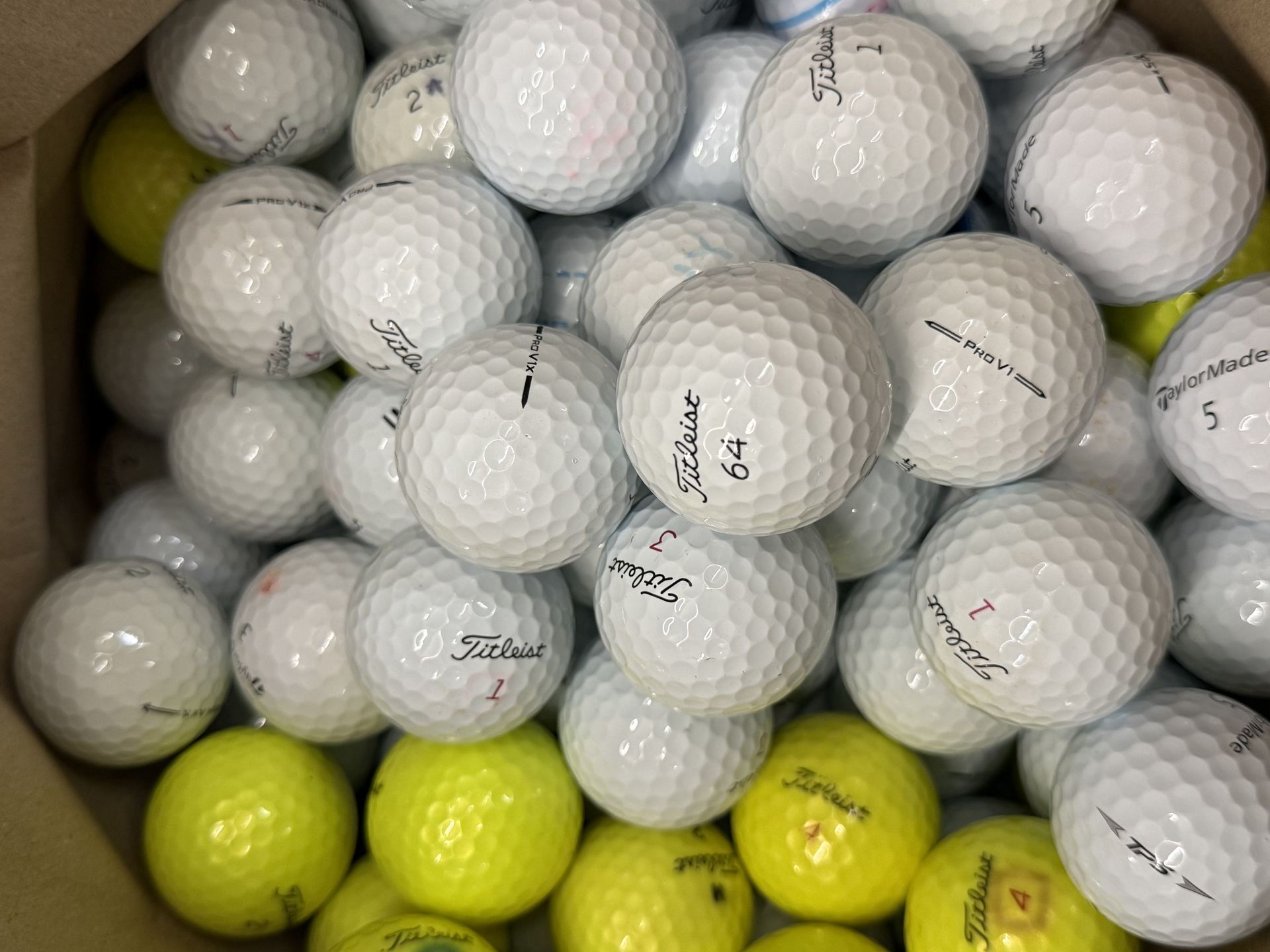 Boxes of sorted Titleist Pro V1 golf balls ready for grading at KL Golf Hub